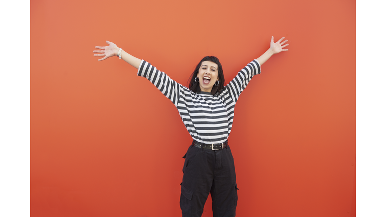 Young woman with arms outstretched in carefree moment.