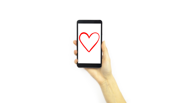 Hand holding a phone with a heart on it