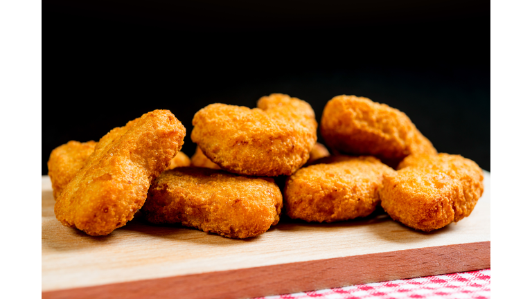 Close-Up Of Chicken Nuggets On Cutting Board Against Black Background