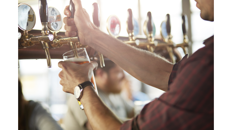 Close-up of bartender making cask beers at bar