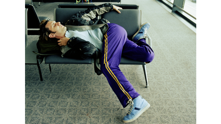 Man sleeping in airport terminal, elevated view