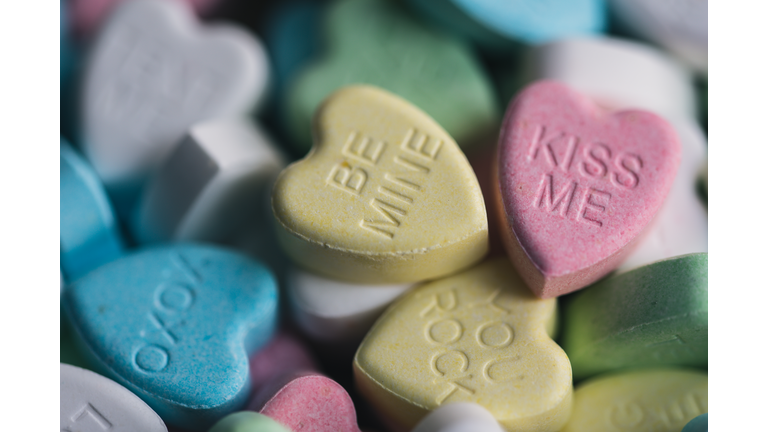 Close up of candy hearts with Valentine's messages on them.
