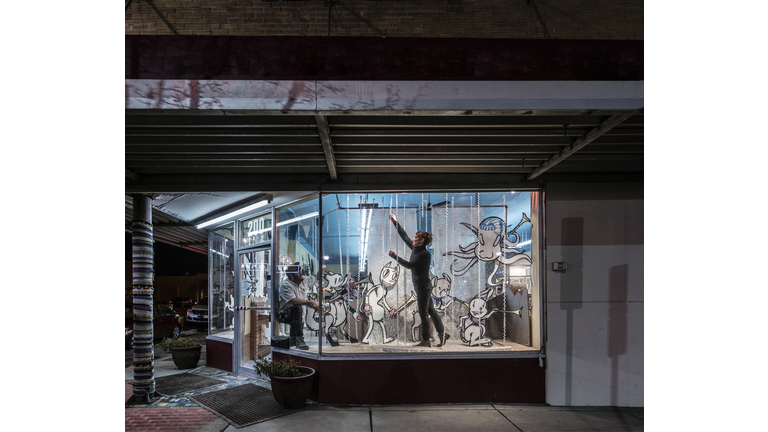 Man and woman decorating display window in music store