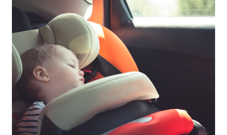 Baby sleeping in car safety seat while travelling