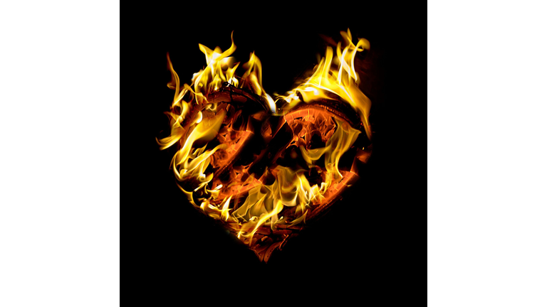 Close-Up Of Heart Shape Fire Against Black Background