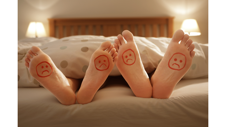 couples unhappy feet in bed