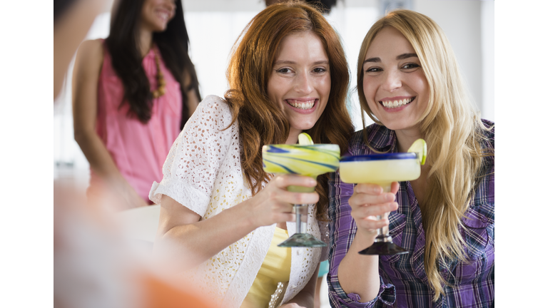 Women toasting each other with margaritas