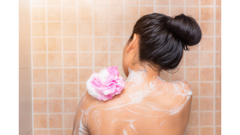 Rear View Of Woman Taking Bath At Bathroom