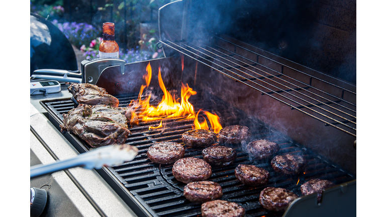 Lamb joint and burgers on a barbecue