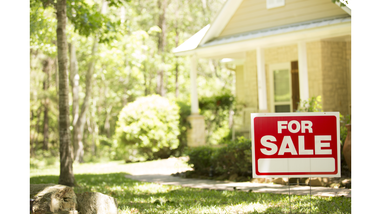 Home for sale with real estate sign.