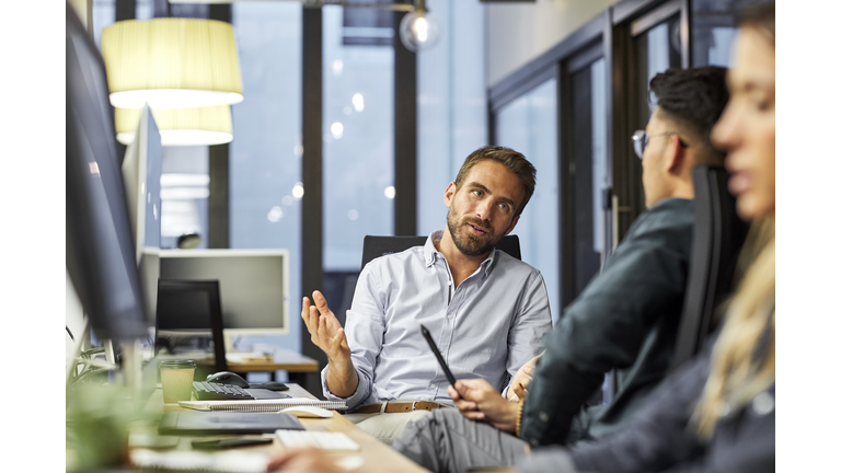 Male coworkers discussing during meeting in office