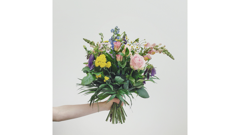 Hand holding bouquet of flowers