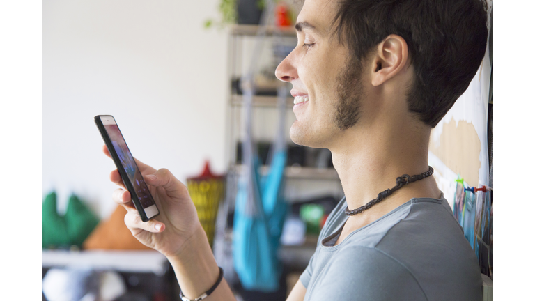 Young man using smartphone at home