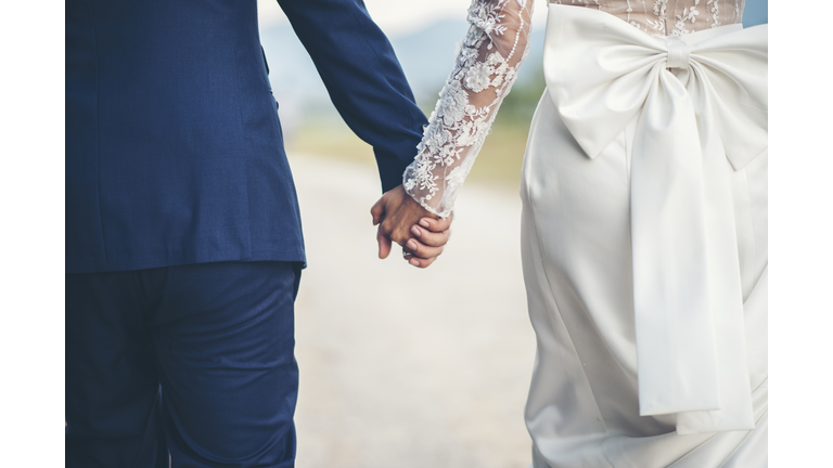 Midsection Of Couple Holding Hands While Walking Outdoors