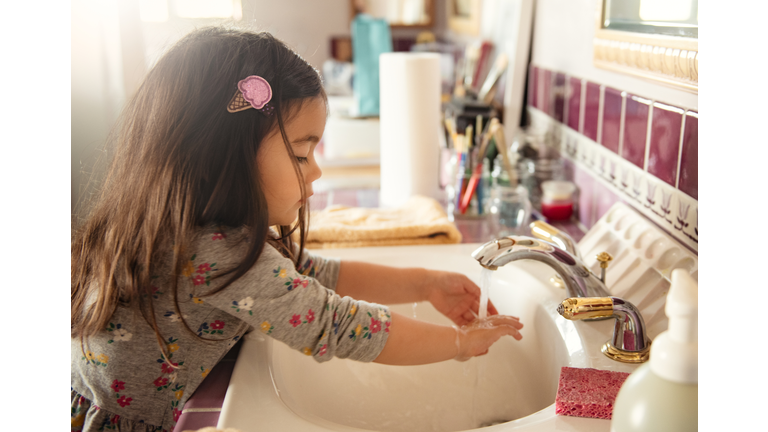 Toddler Girl Washing Her Hands After Painting