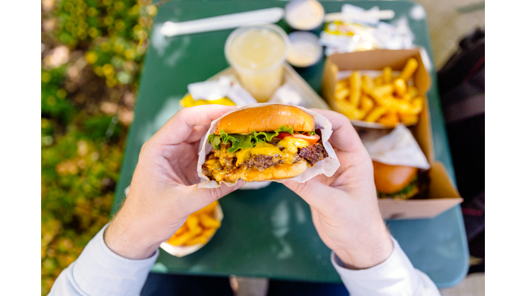 Man eating cheeseburger, personal perspective view