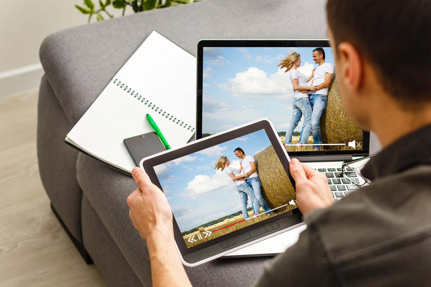 Online streaming concept: man using a laptop with online streaming website on the screen. Screen graphics are made up.