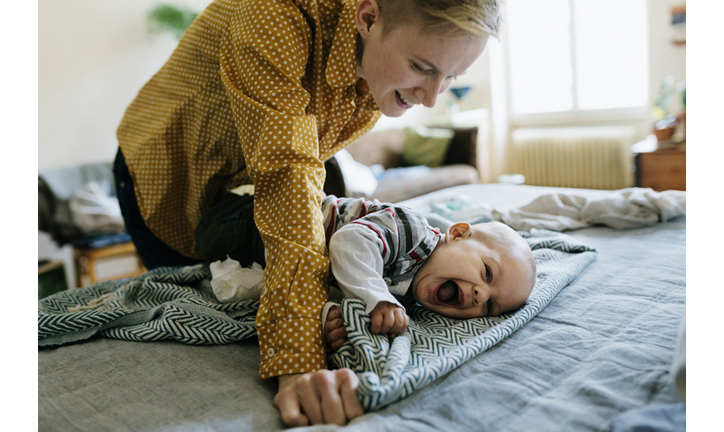 Single Mother Playing With Baby After Getting Dressed