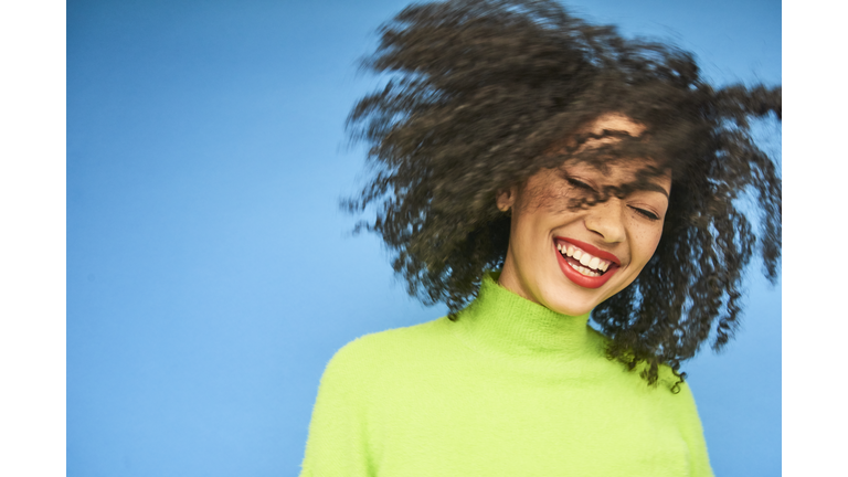 Colourful studio portrait of a young woman dancing