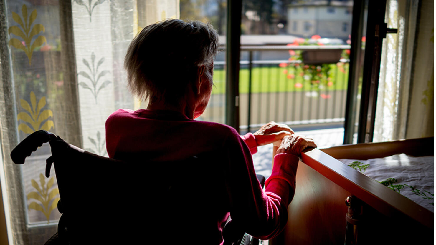 Disabled senior woman in wheelchair at home in living room