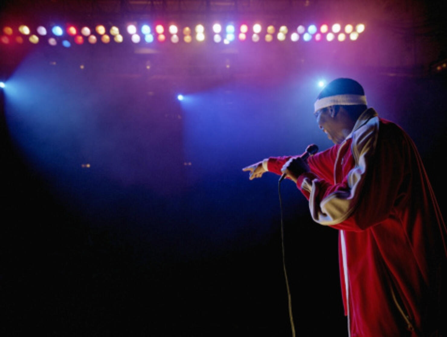 Comedian standing on stage pointing towards audience, rear view