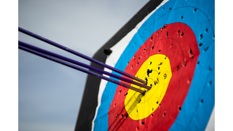 Close up on three arrows in the middle center of the target goal achieved success archery