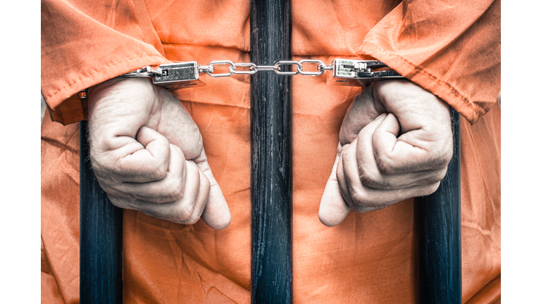 Close-Up Of Man With Handcuffs Standing In Prison