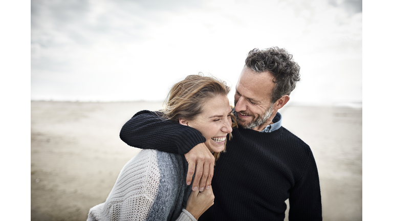 Happy couple hugging on the beach