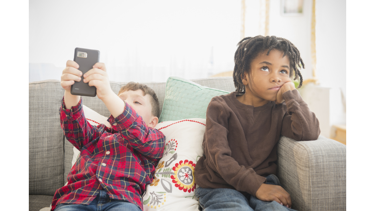 Boy with cell phone ignoring friend