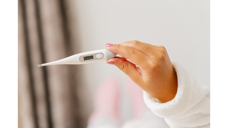 Cropped Hand Of Woman Holding Thermometer At Home