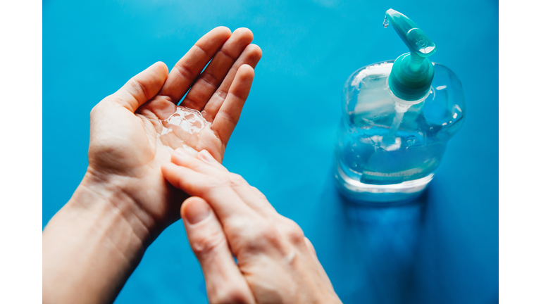 Woman disinfecting hands during the Coronavirus pandemic, also known as covid19