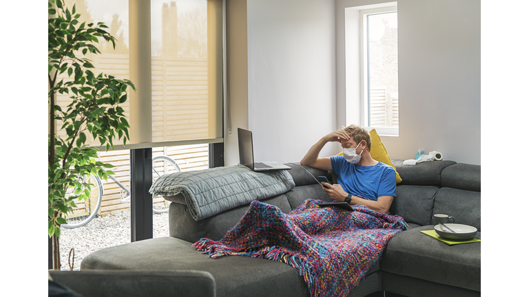 Man in self isolation on the sofa with the flu