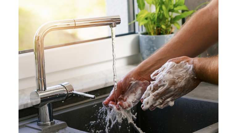 Cropped Hands Of Man Washing Hands At Sink