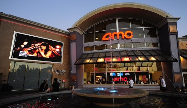 A couple watch a big screen outside movi