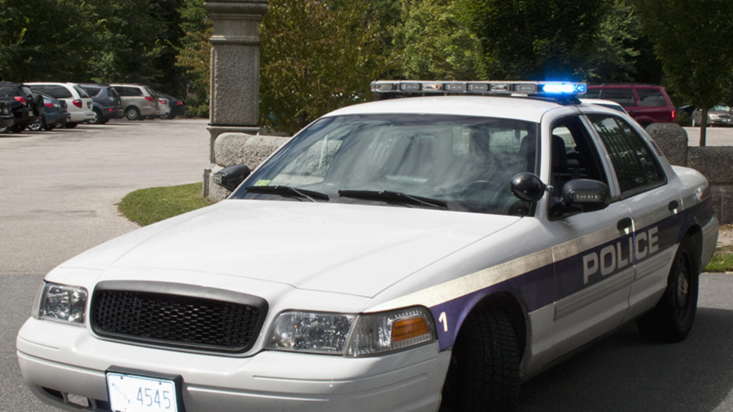 A police car with its emergency lights on parked on a street