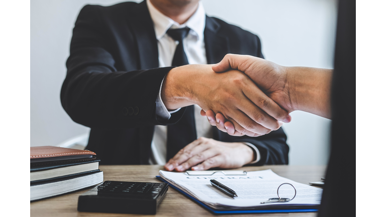 Cropped Hands Of Real Estate Agent Giving Handshake To Customer In Office