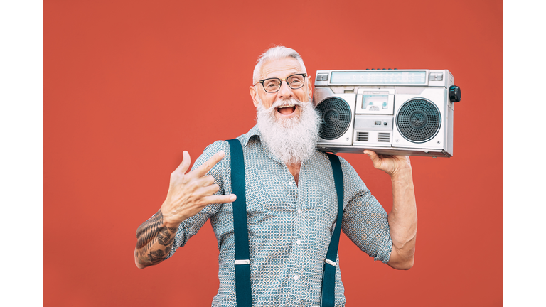 Hipster Senior Man Listening Music On Radio Against Red Background