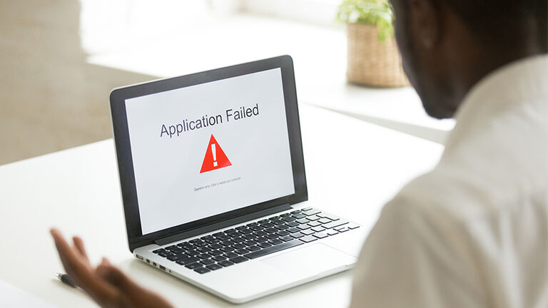 Frustrated worker getting virus notification at laptop scr