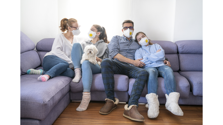 Family at sofe with mask in quarantine isolation against virus