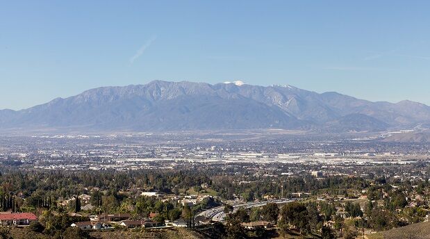 Aerial View Of Townscape And Mountains Against Clear Blue Sky