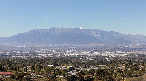 Aerial View Of Townscape And Mountains Against Clear Blue Sky