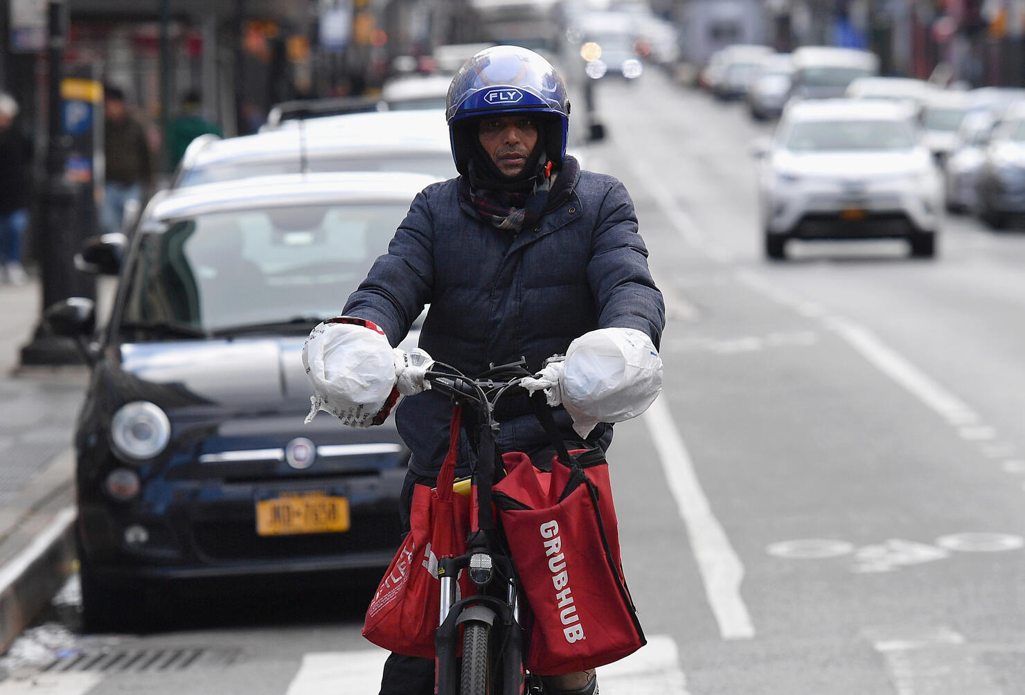 A delivery person rides his bike in Brooklyn, New York on March 17, 2020. - Food delivery workers have become essential in New York after the city closed restaurants and bars to the public on March 16th, 2020. They are taking extreme precautions not to get sick, but most of them are immigrants with no papers and no health insurance.
