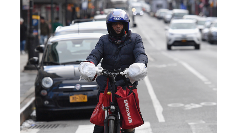 A delivery person rides his bike in Brooklyn, New York on March 17, 2020. - Food delivery workers have become essential in New York after the city closed restaurants and bars to the public on March 16th, 2020. They are taking extreme precautions not to get sick, but most of them are immigrants with no papers and no health insurance.