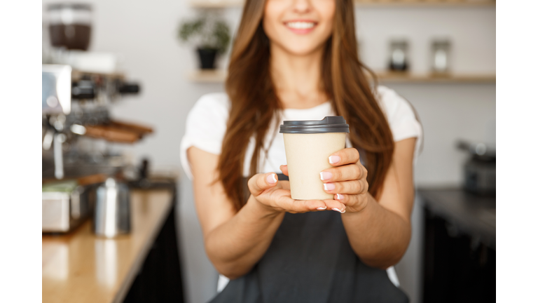 Midsection Of Barista Holding Disposable Coffee Cup While Standing At Cafe