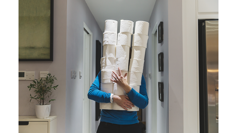 Person holding large piles of toilet rolls