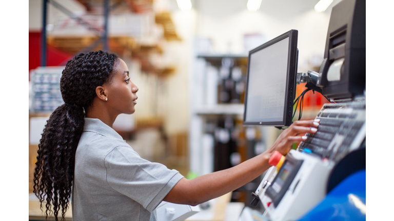 Female worker working on a machine in factory