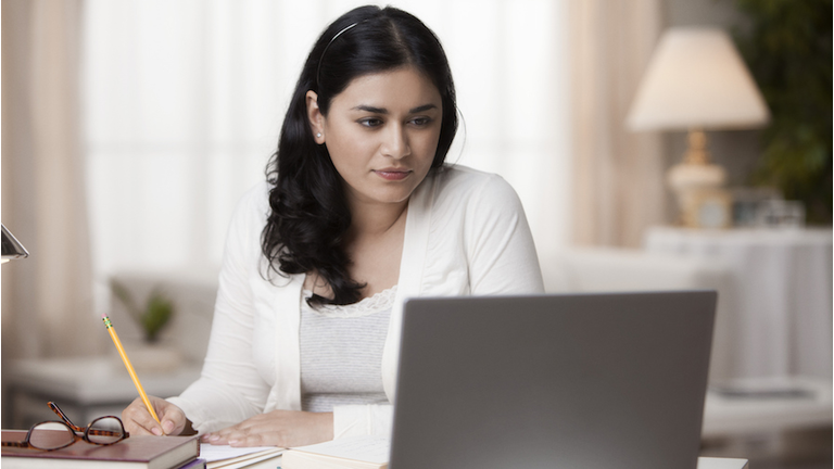 Mixed race woman studying on laptop