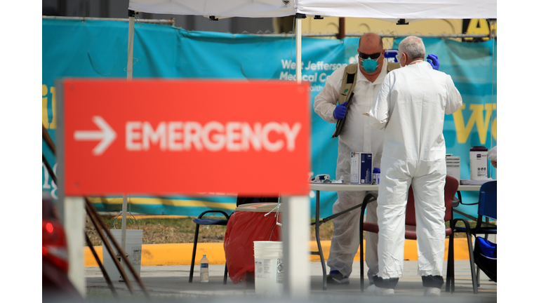 Medical personnel talk at a drive-thru Coronavirus COVID-19 testing station at West Jefferson Medical Center on March 17, 2020. (Photo by Chris Graythen/Getty Images)