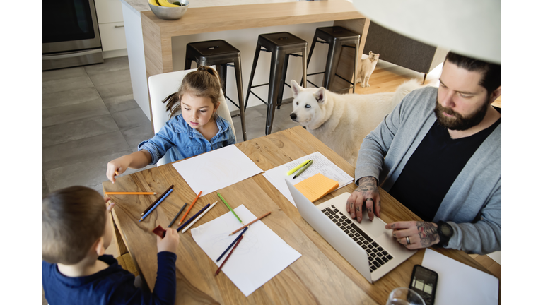 Father working from home with young children in quarantine isolation Covid-19