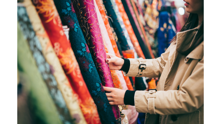 Fashion designer shopping for colourful fabrics in fabric store